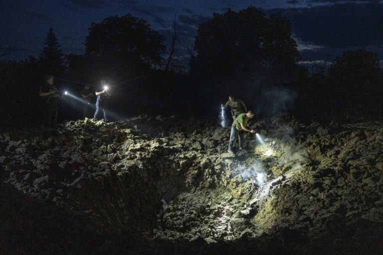 Ukrajinskí policajti hľadajú úlomky rakety v kráteri po ruskom raketovom útoku na obytnú štvrť v ukrajinskom Pokrovsku 21. júna 2023. Foto: TASR/AP