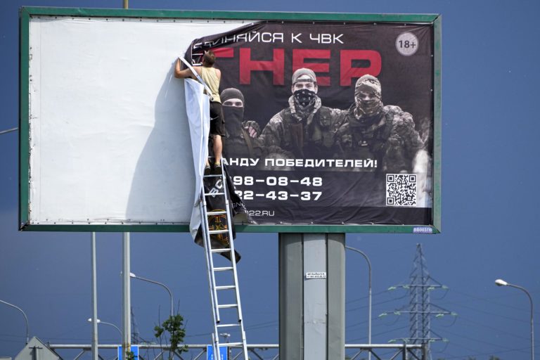 Muž odstraňuje náborový bilbord vagnerovcov v Petrohrade, ilustračný obrázok. Foto: TASR/AP