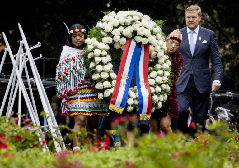 Holandský kráľ Viliam Alexander (vpravo) kladie veniec pri príležitosti 150. výročia zrušenia otroctva v bývalých holandských kolóniách v Amsterdame. Foto: TASR/AP      
