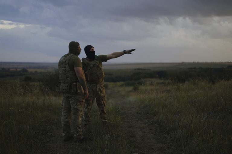 Ukrajinský vojak z 3. samostatnej útočnej brigády ukazuje na fronte svojmu spolubojovníkovi pozície ruskej armády neďaleko mesta Bachmut. Foto: TASR/AP