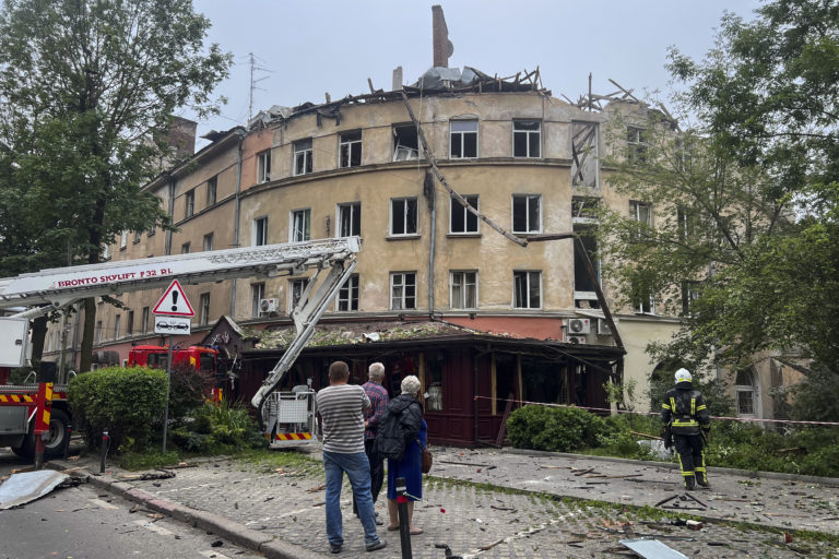 Ľudia stoja pred poškodenou budovou po ruskom raketovom útoku v Ľvove na Ukrajine vo štvrtok 6. júla 2023. Foto: TASR/AP
