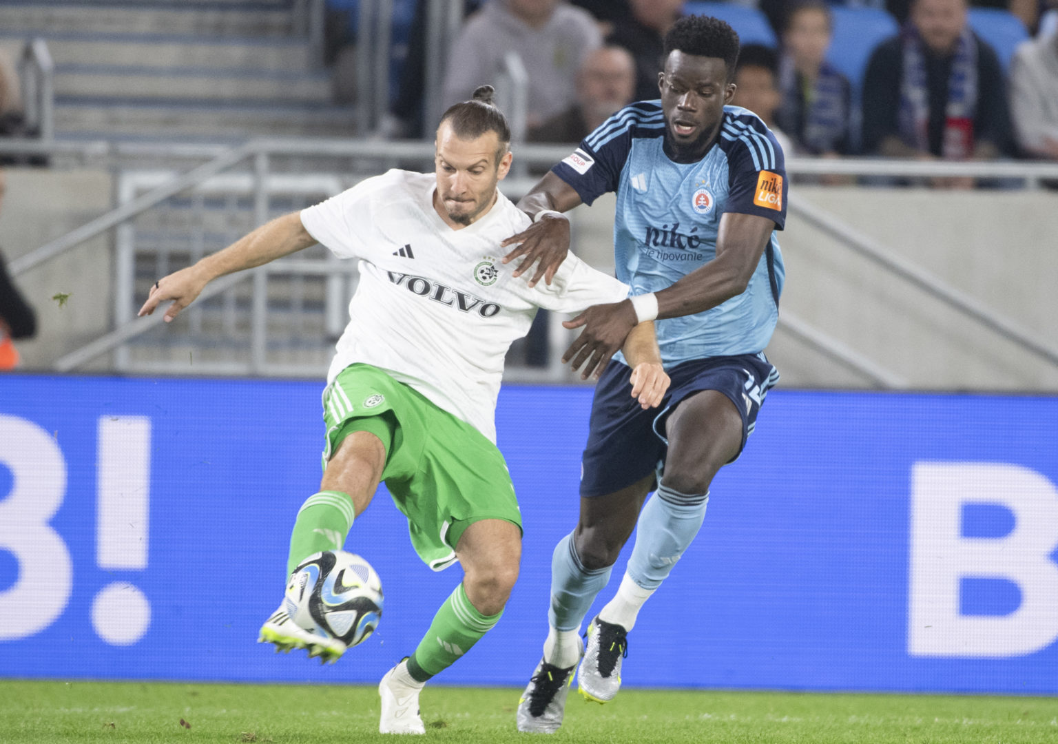 Na snímke zľava hráč Haify Sean Goldberg a hráč Slovana Malik Abubakari v prvom zápase 3. predkola Ligy majstrov vo futbale ŠK Slovan Bratislava - Maccabi Haifa v stredu 9. augusta 2023 v Bratislave. Foto: Martin Baumann/TASR