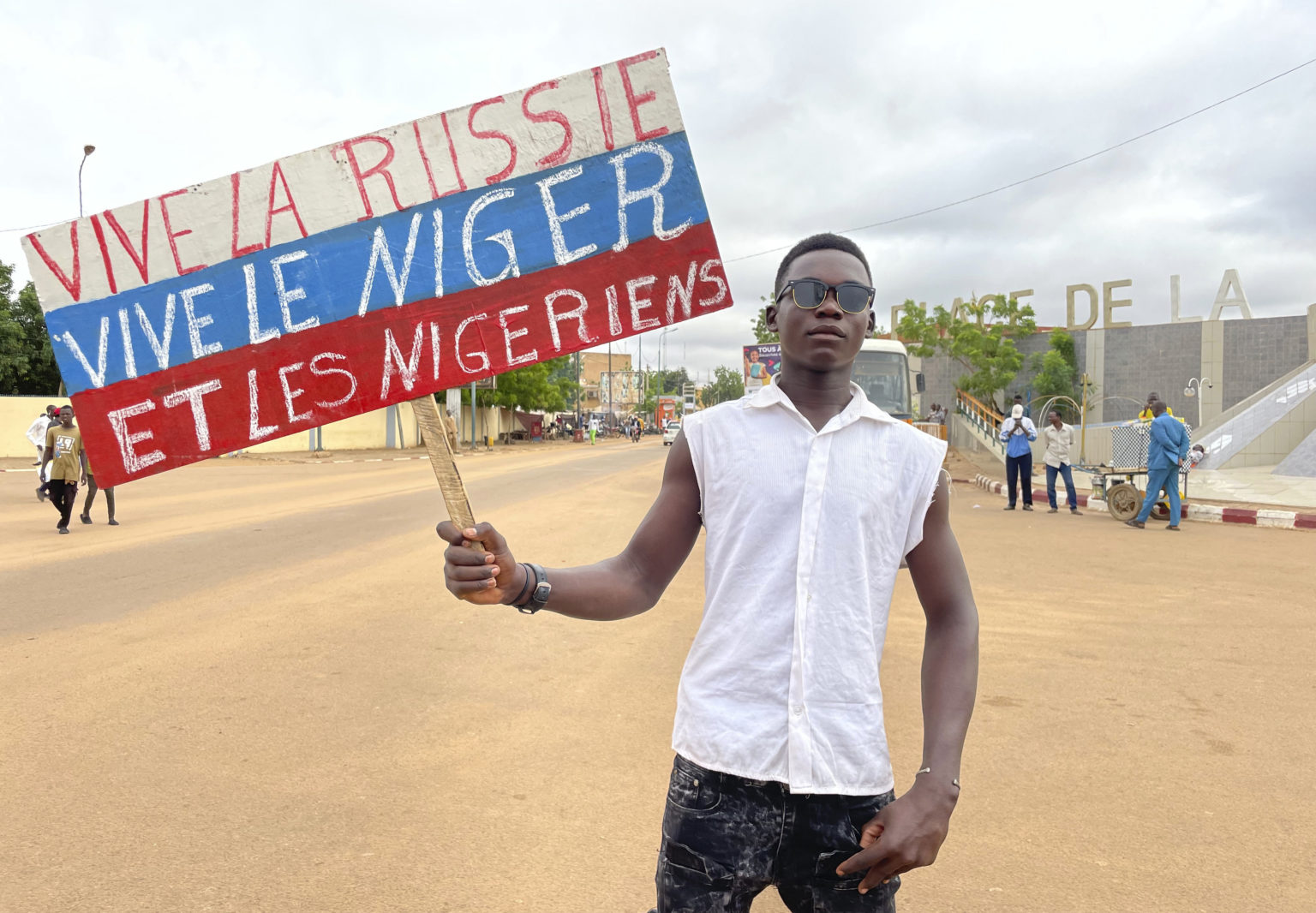 Stúpenec nigerskej vládnucej junty drží transparent vo farbách ruskej vlajky s nápisom “Nech žije Rusko, nech žije Niger a Nigerčania”  na začiatku protestu za slobodu krajiny a proti zahraničnému zasahovaniu v nigerskom Niamey 3. augusta 2023. Foto: TASR/AP