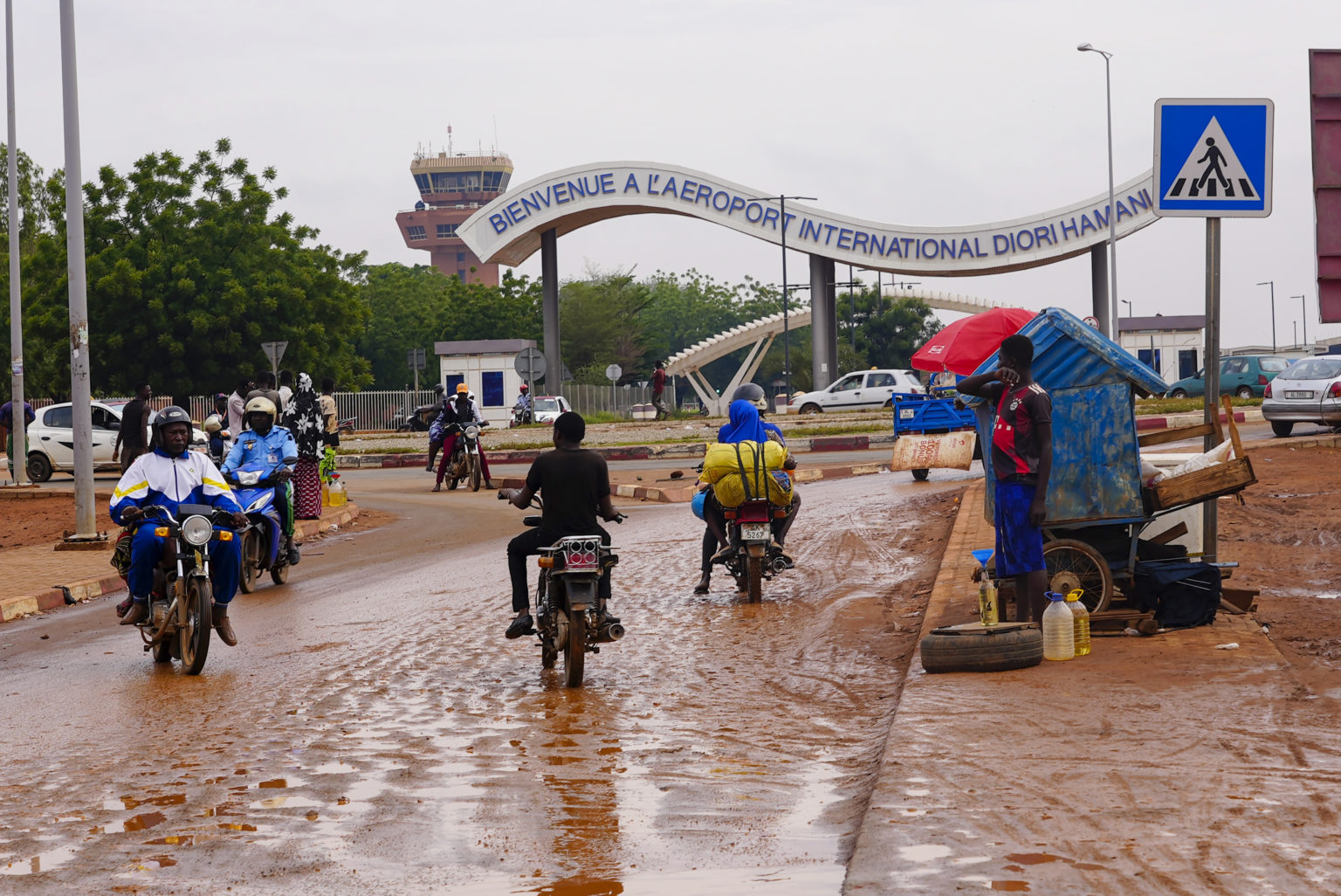 Motocyklisti jastia pred vstupom na letisko v Niamey. Foto: TASR/AP