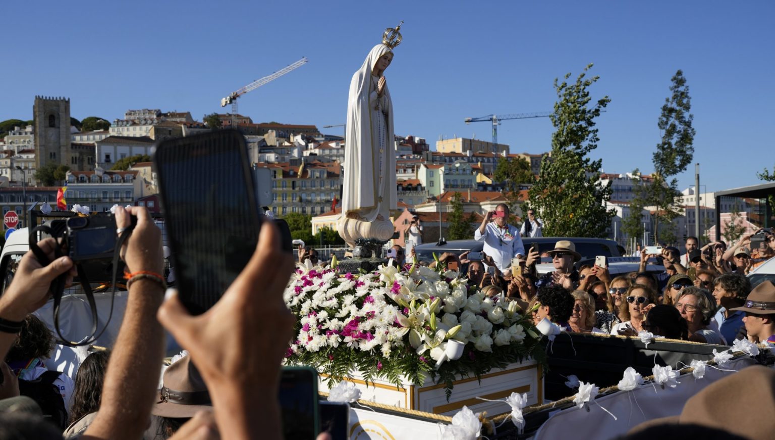 Ľudia fotografujú repliku sochy Panny Márie Fatimskej po tom, čo loďou dorazila z Fatimy do Lisabonu na Svetových dní mládeže. Foto: TASR/AP 