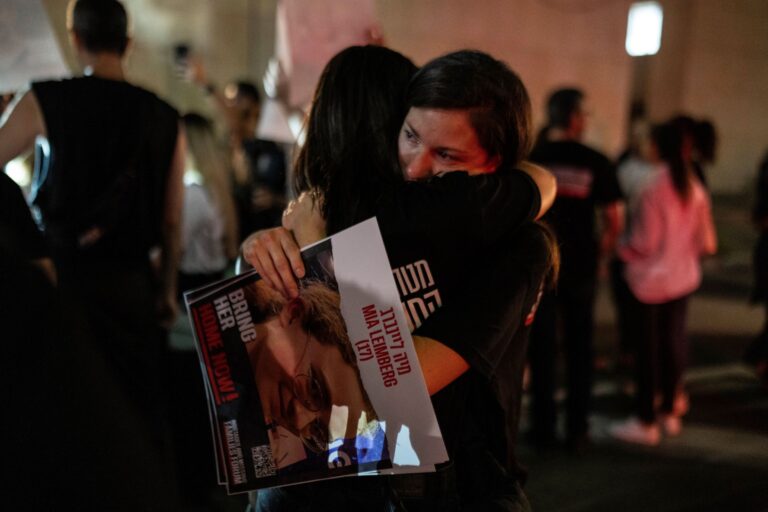 Príbuzní ľudí unesených militantmi z Hamasu sa objímajú držiac fotografiu svojich blízkych počas protestu v Tel Avive v sobotu 21. októbra 2023. Foto: Petros Giannakouris TASR/AP