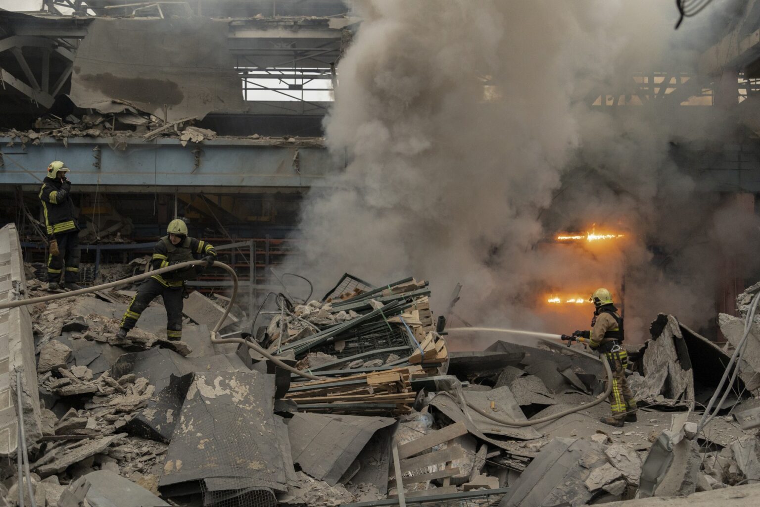 Ukrajinskí záchranári pracujú na mieste raketového útoku na civilnú továreň v Charkove na severovýchode Ukrajiny, 29. decembra 2023. Foto: Profimedia.sk