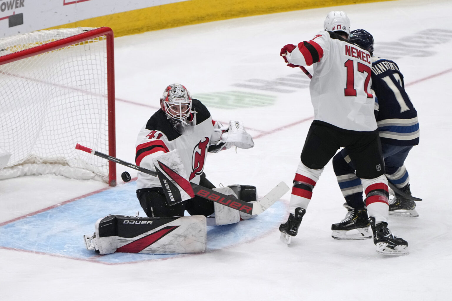 Brankár New Jersey Devils Vítek Vaněček (41) blokuje strelu pred obrancom Šimonom Nemcom (17) a pravým krídlom Columbusu Blue Jackets Justinom Danforthem (17) počas druhej tretiny hokejového zápasu NHL v piatok 19. januára 2024 v Columbuse v Ohiu. Foto: TASR/AP