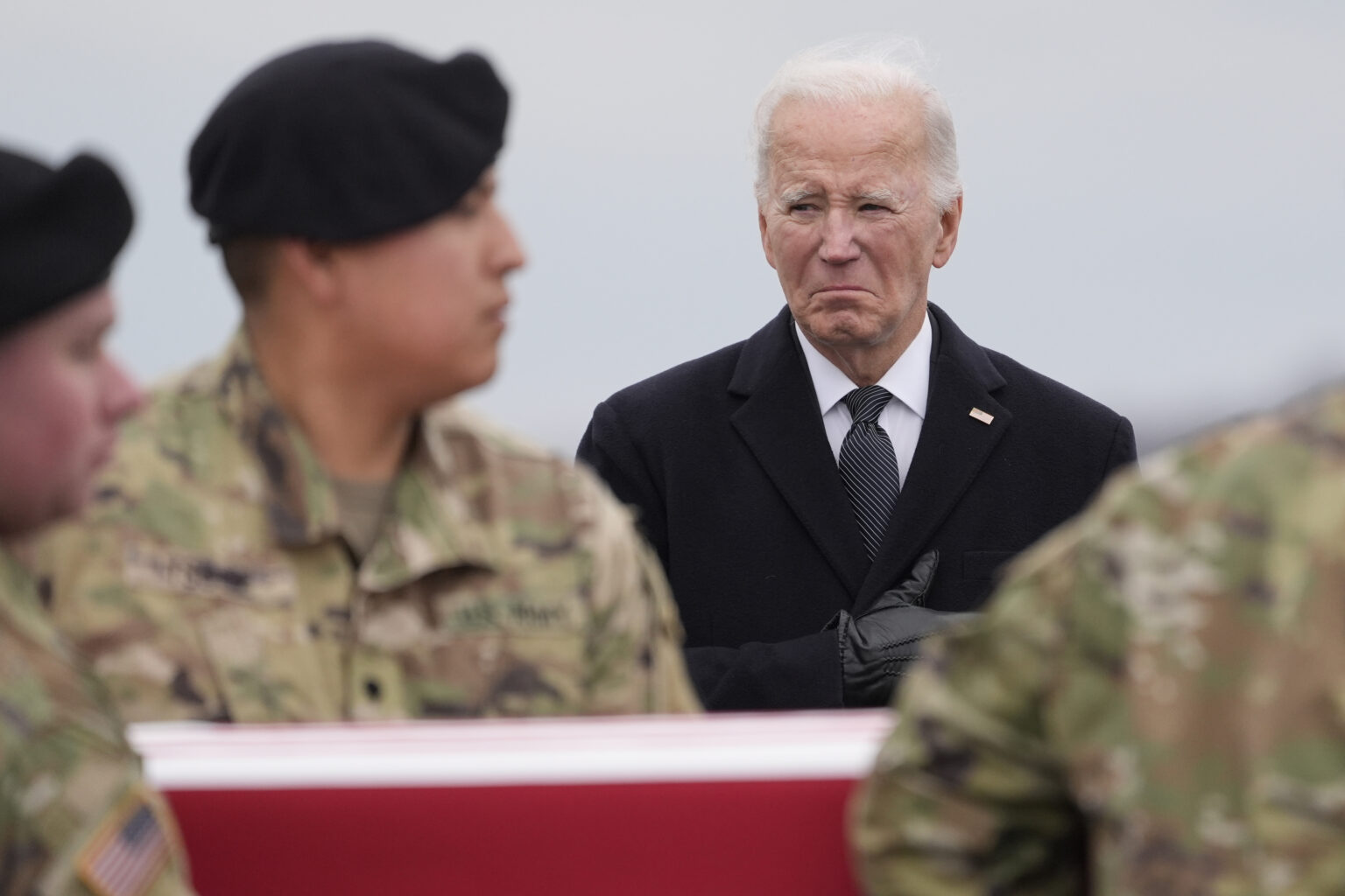 Joe Biden (vpravo) stojí, zatiaľčo príslušníci americkej armády vynášajú rakvu s pozostatkami amerického vojaka, seržanta Kennedyho Ladona Sandersa, ktorý zahynul pri útoku dronom na vojenskej základni na severovýchode Jordánska v nedeľu 28. januára. Foto: TASR/AP