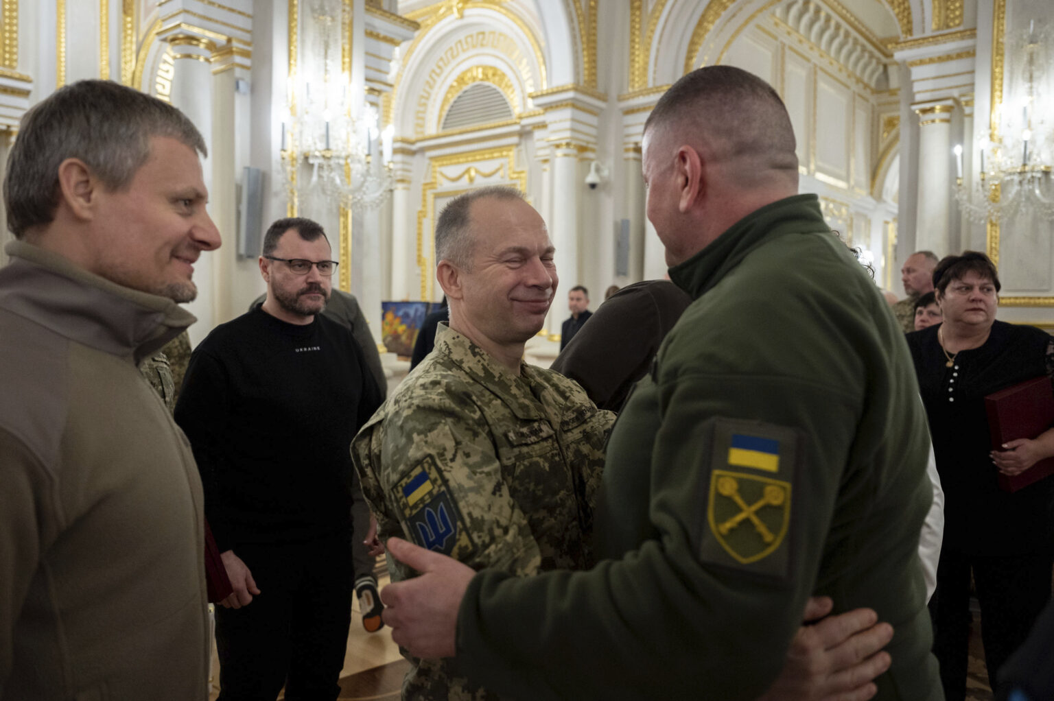Na snímke bývalý veliteľ ozbrojených síl Ukrajiny Valerij Zalužnyj (vpravo) a veliteľ ozbrojených síl Ukrajiny Olexandr Syrskyj sa objímajú počas slávnostného ceremoniálu v piatok 9. februára 2024 v Kyjeve. Foto: TASR/AP