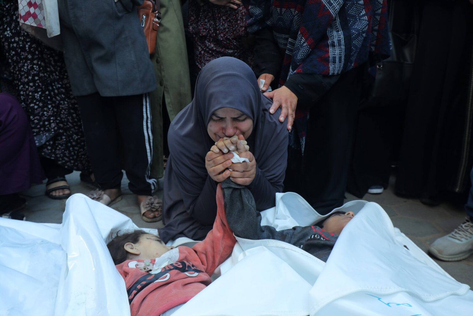 Palestínska matka Asmaa Naserová oplakáva telá svojich dvojčiat, ktoré zahynuli v dôsledku izraelského náletu na tábor Nuseirat, v nemocnici mučeníkov Al-Aksá v Deír al-Baláh v centrálnej časti pásma Gazy 29. decembra 2023. Foto: Profimedia.sk