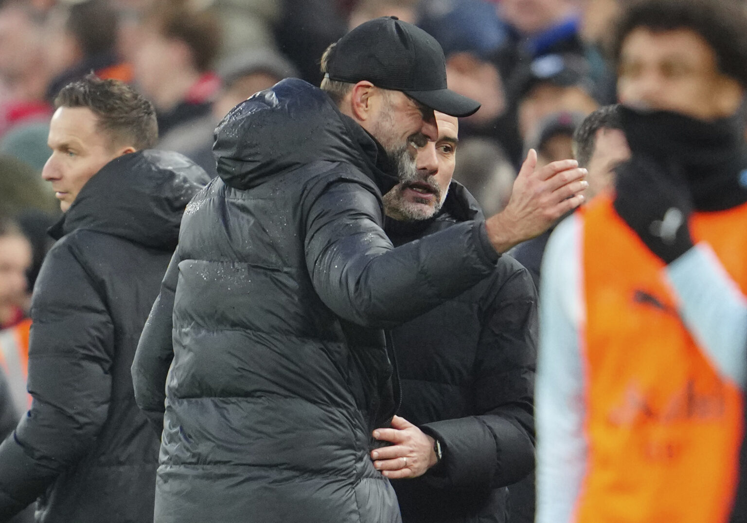 Tréner Liverpoolu Jürgen Klopp (uprostred) a tréner Manchestru City Pep Guardiola sa objímajú po šlágri 28. kola anglickej Premier League FC Liverpool - Manchester City v Liverpoole v nedeľu 10. marca 2024. Zápas sa skončil remízou 1:1. Foto: TASR/AP