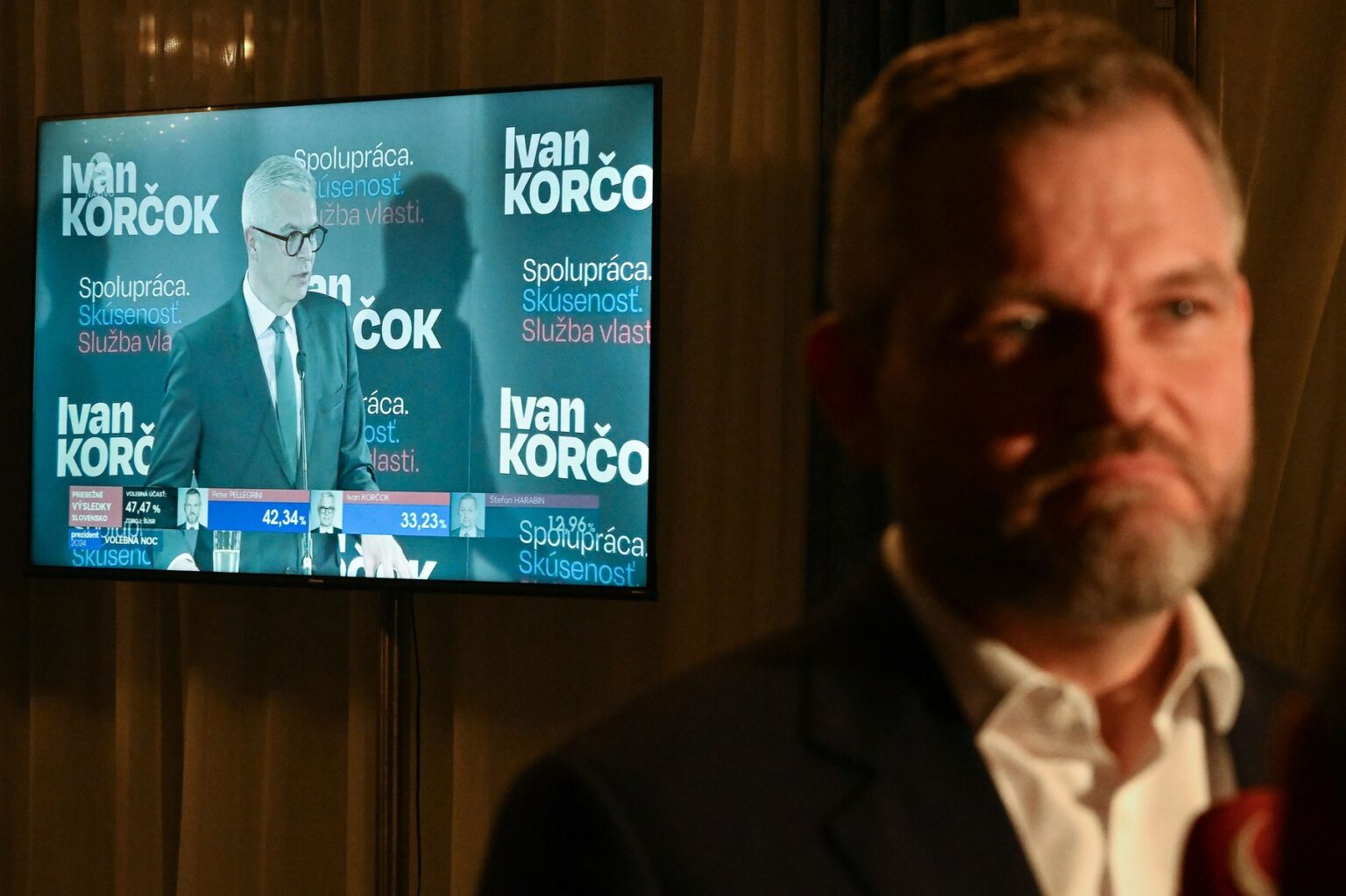 Peter Pellegrini a na televíznej obrazovke jeho hlavný protikandidát Ivan Korčok. Foto: Profimedia.sk
