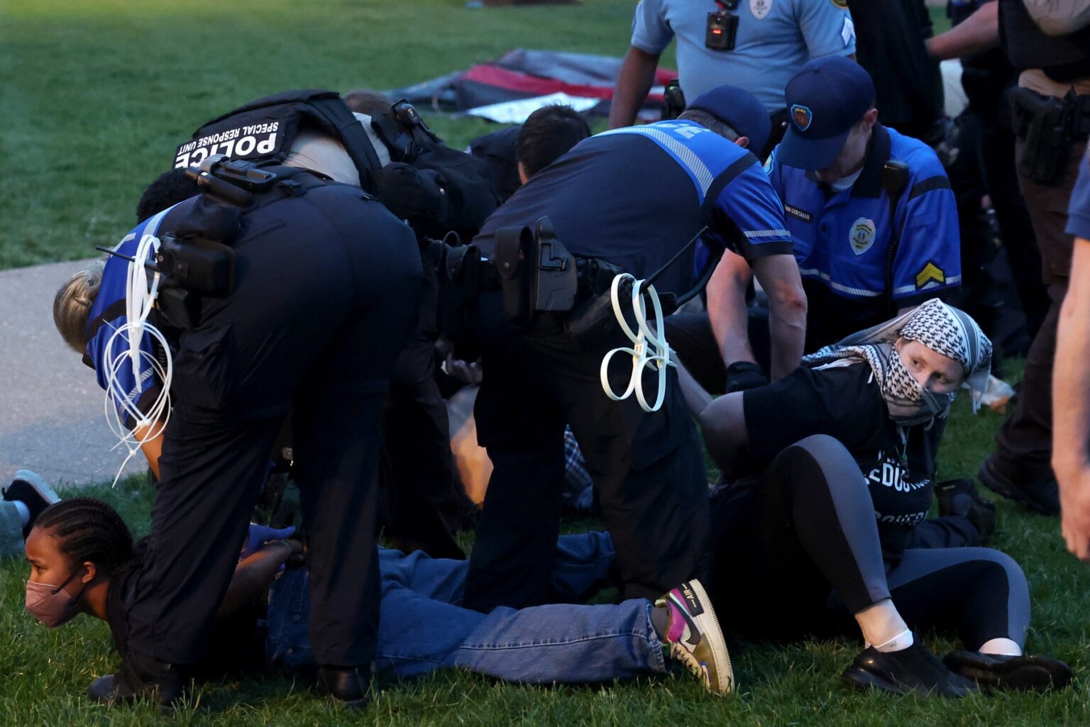 Polícia zatýka študentských demonštrantov, ktorí sa pokúšajú stanovať na podporu Palestíny v sobotu 27. apríla 2024 v areáli Washingtonovej univerzity v St. Louis. Počas protestu boli zatknuté desiatky ľudí. Zdroj: Profimedia