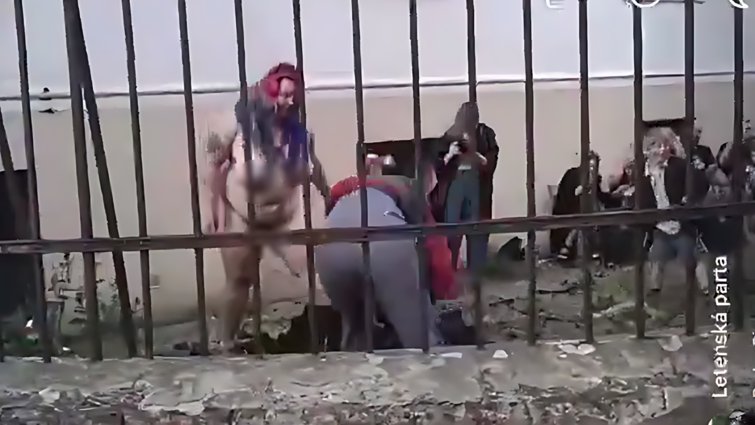 Nahá žena okolo seba rozhadzuje hlinu zatiaľ čo sa deti pozerajú. Reprofoto X