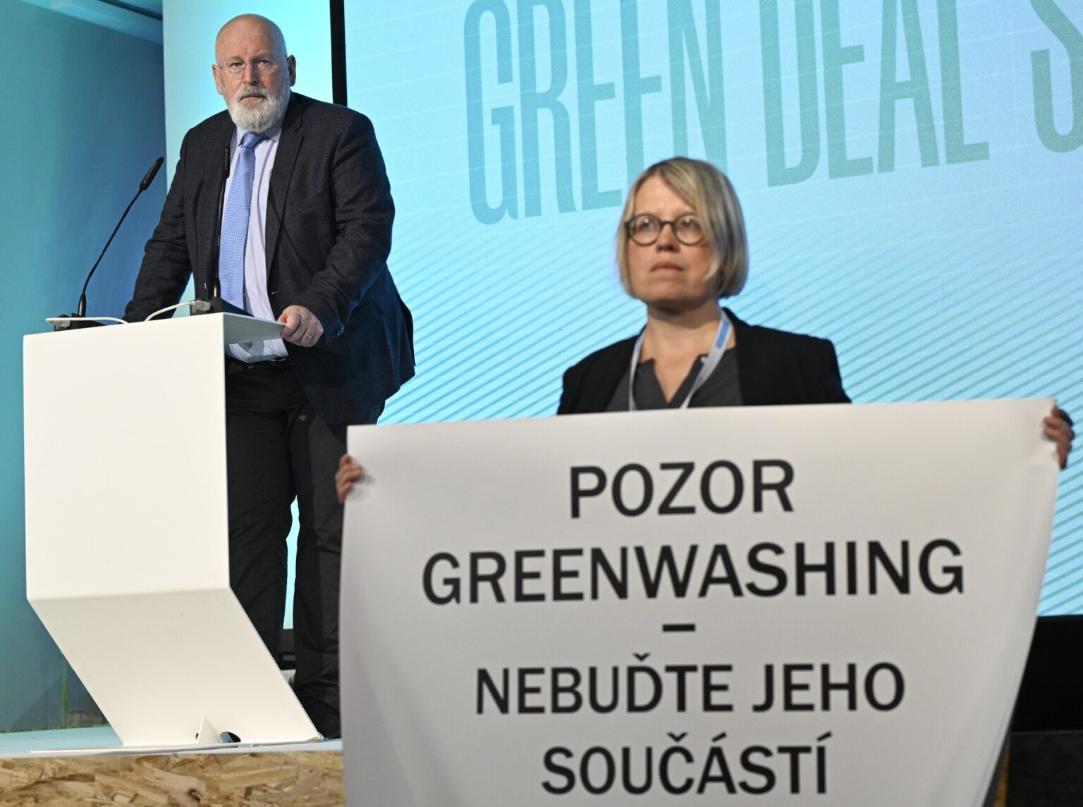 Podpredseda Európskej komisie Frans Timmermans reční na samite o Green Deal, 26. septembra 2022, Praha. Dole protest Petry Kolínskej z asociácie environmentálnych organizácií Zelený kruh. Zdroj: Profimedia