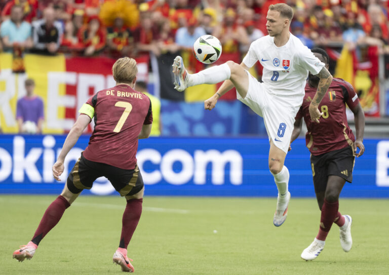 Slovenský futbalista Ondrej Duda (uprostred) a kapitán Belgicka Kevin De Bruyne (vľavo) bojujú o loptu v zápase E-skupiny Belgicko - Slovensko na ME vo futbale vo Frankfurte v pondelok 17. júna 2024. Foto: Martin Baumann/TASR