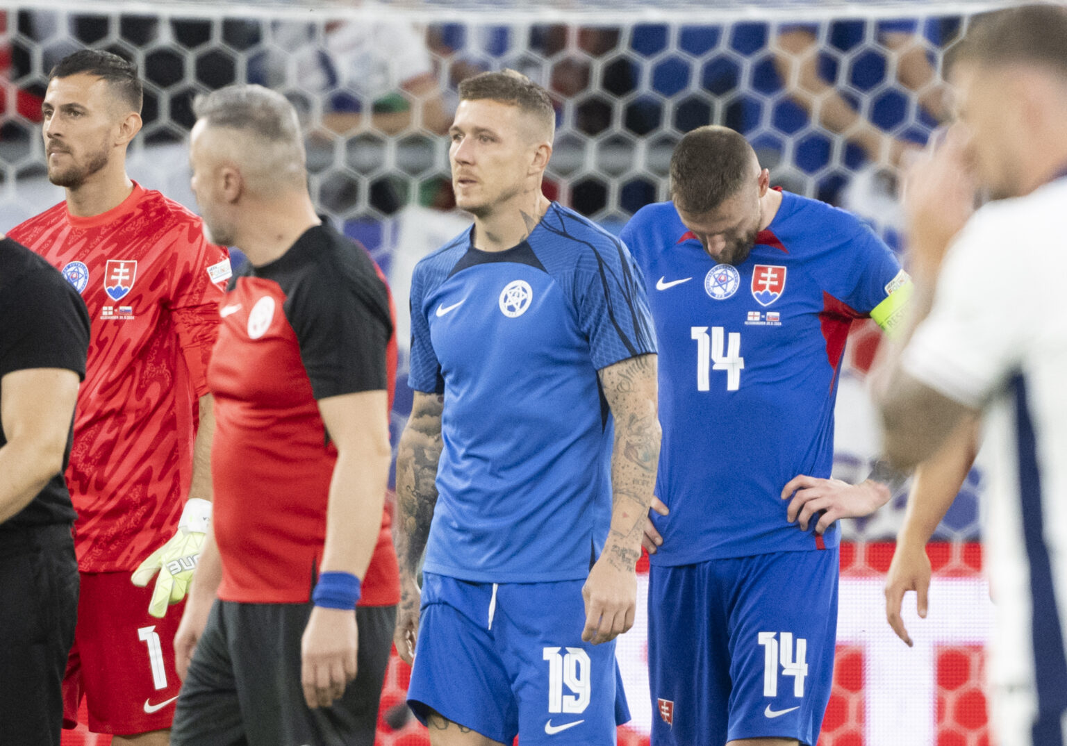 Na snímke sprava kapitán Milan Škriniar (Slovensko) a Juraj Kucka a brankár Martin Dúbravka reagujú po prehre v osemfinálovom zápase Anglicko - Slovensko na ME vo futbale v nemeckom meste Gelsenkirchen v nedeľu 30. júna 2024.  Foto: Martin Baumann/TASR