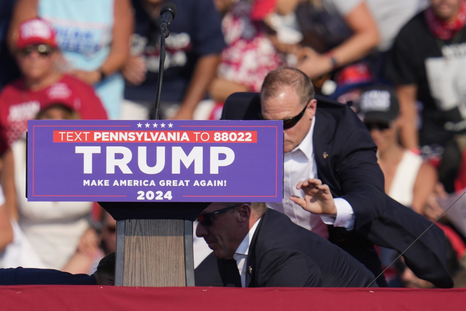 Agenti americkej tajnej služby obklopujú republikánskeho prezidentského kandidáta a amerického exprezidenta Donalda Trumpa po pokuse o atentát na jeho osobu na jeho predvolebnom mítingu v meste Butler v americkom štáte Pensylvánia. Foto: TASR/AP     