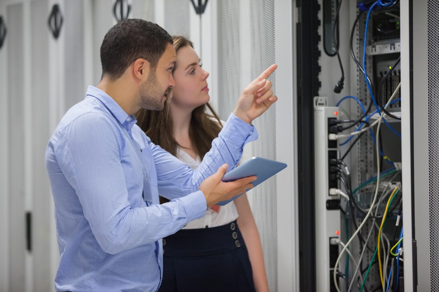 Technici sa pozerajú na servery v dátovom centre pomocou testovacieho tabletu. Foto: Profimedia