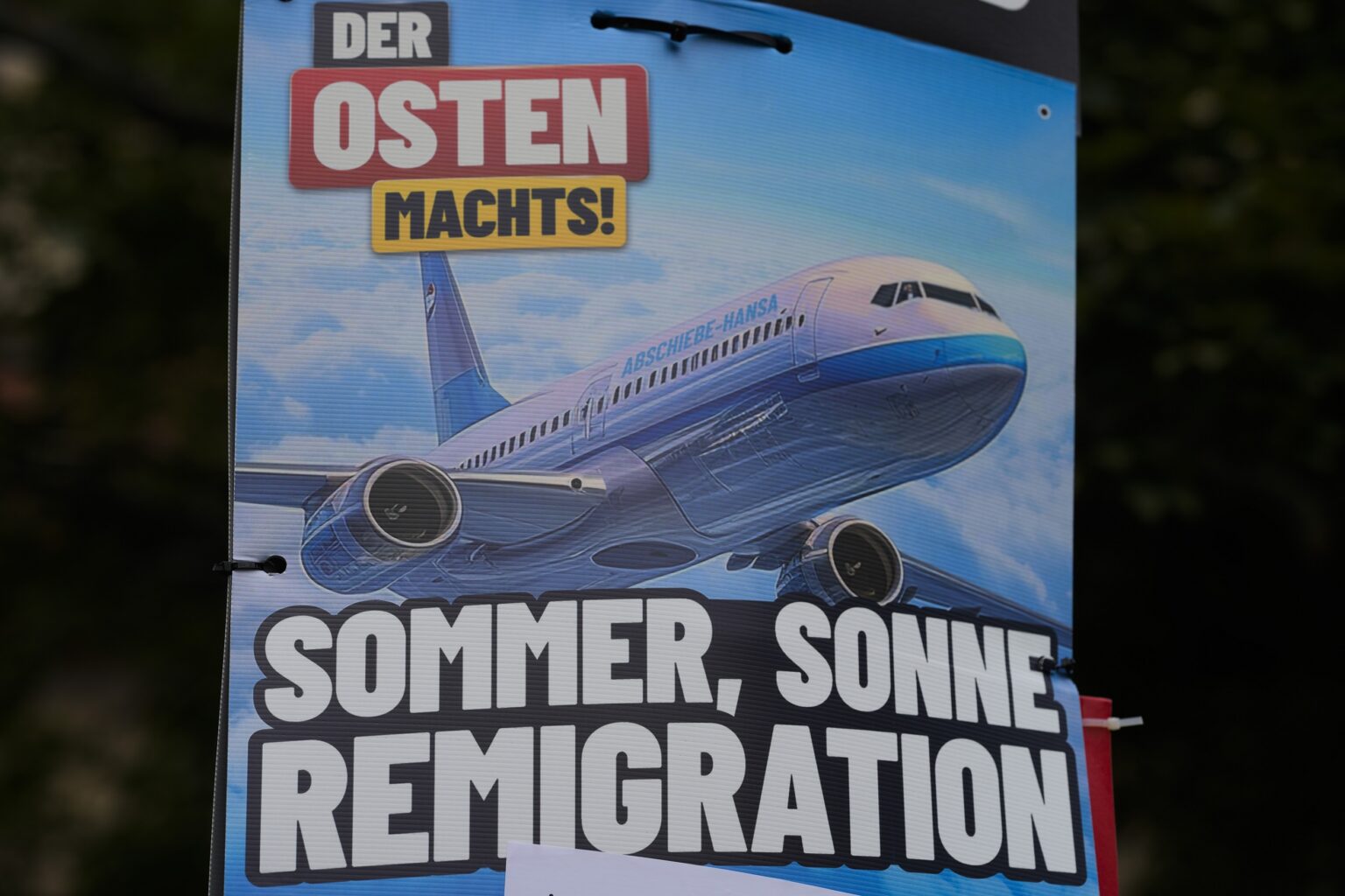 Volebný plagát Alternatívy pre Nemecko (AfD) s logom "Leto, slnko, remigrácia" a fotografiou lietadla s názvom "Deportačná letecká spoločnosť" visí v nemeckom Erfurte. Foto: TASR/AP  