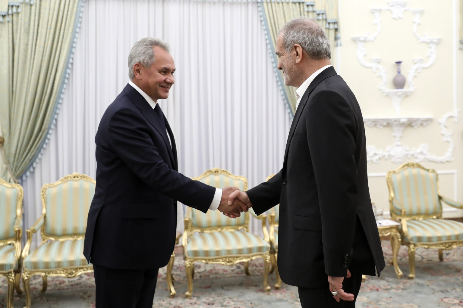 Prezident Masúd Pezeškján (vpravo) si podáva ruku s tajomníkom ruskej Bezpečnostnej rady Sergejom Šojguom na začiatku ich stretnutia v Teheráne. Foto: TASR/AP