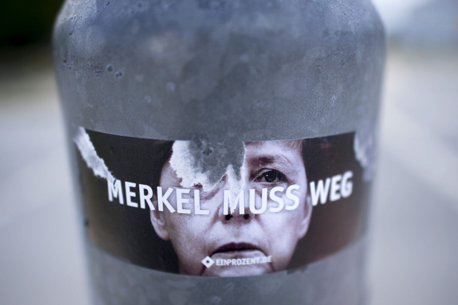 Poškodená nálepka s nápisom "Merkelová musí odísť" v nemeckom Cottbuse. Foto: Profimedia.sk