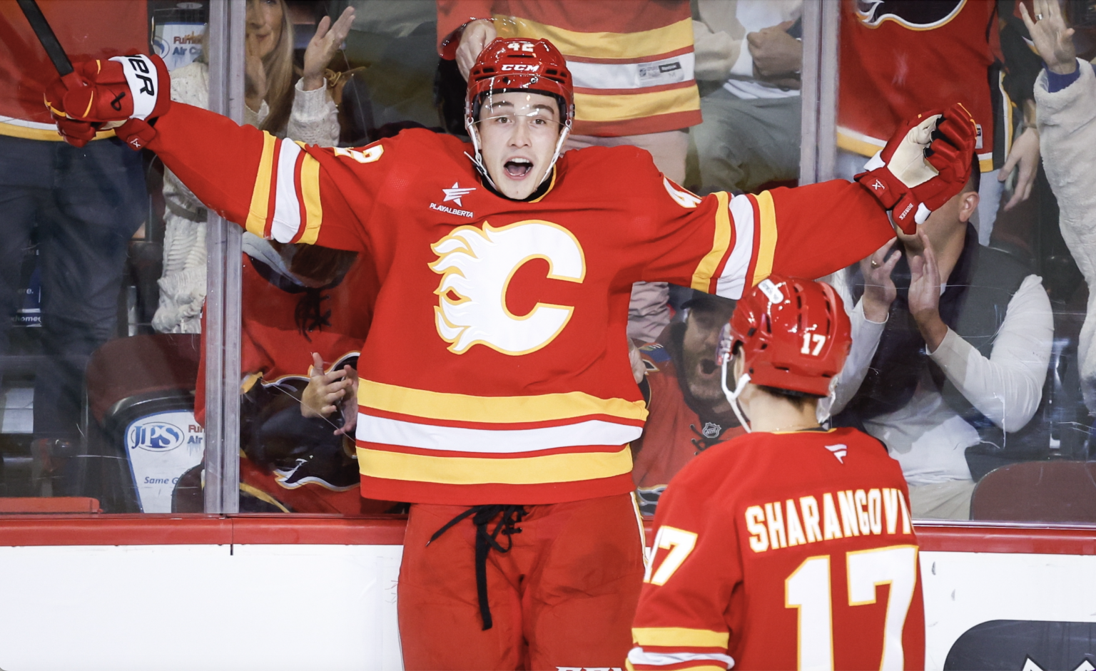 Samuel Honzek (vľavo) a Jegor Šarangovič z Calgary Flames sa radujú z gólu. Foto: TASR/AP