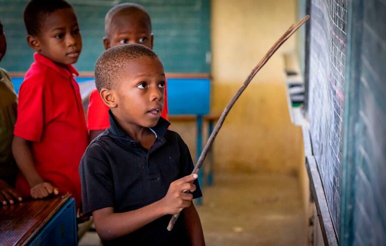 Chlapec prvého ročníka používa malú vetvičku stromu ako ukazovátko, keď recituje pred triedou počas letného vyučovania v Ecole National Louis Borno de Leogane, Haiti, 1. októbra 2024: Zdroj: Jose Iglesias / Zuma Press / Profimedia