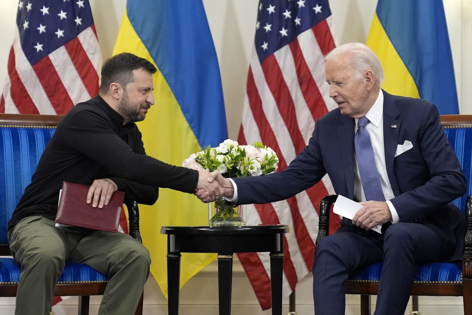 Exprezident USA Joe Biden si podáva ruku s ukrajinským prezidentom Volodymyrom Zelenským v Paríži, piatok 7. júna 2024. Foto: ČTK / AP / Evan Vucci