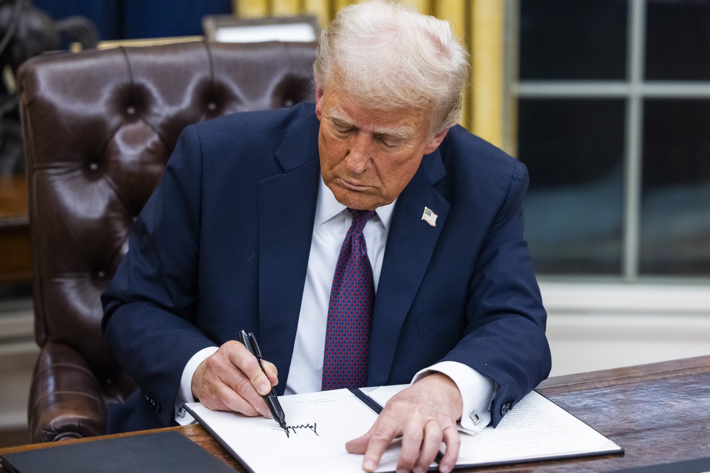 Donald Trump podpisuje počas prvého dňa v úrade výkonné nariadenia. Foto: Jim LoScalzo/Pool via CNP/SplashNews.com/Splash/Profimedia.sk