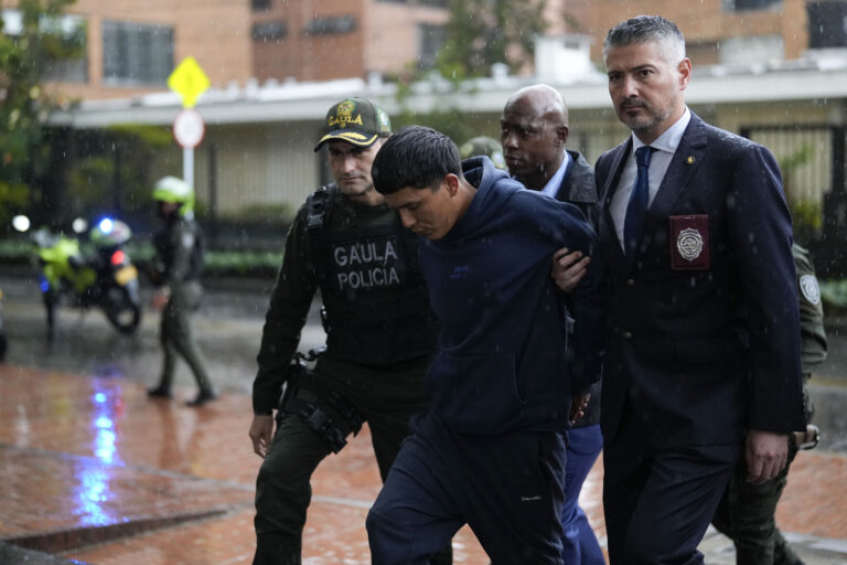 Agenti americkej protidrogovej agentúry DEA a kolumbijskí policajti eskortujú podozrivého z členstva v gangu Tren de Aragua. Foto: TASR/AP