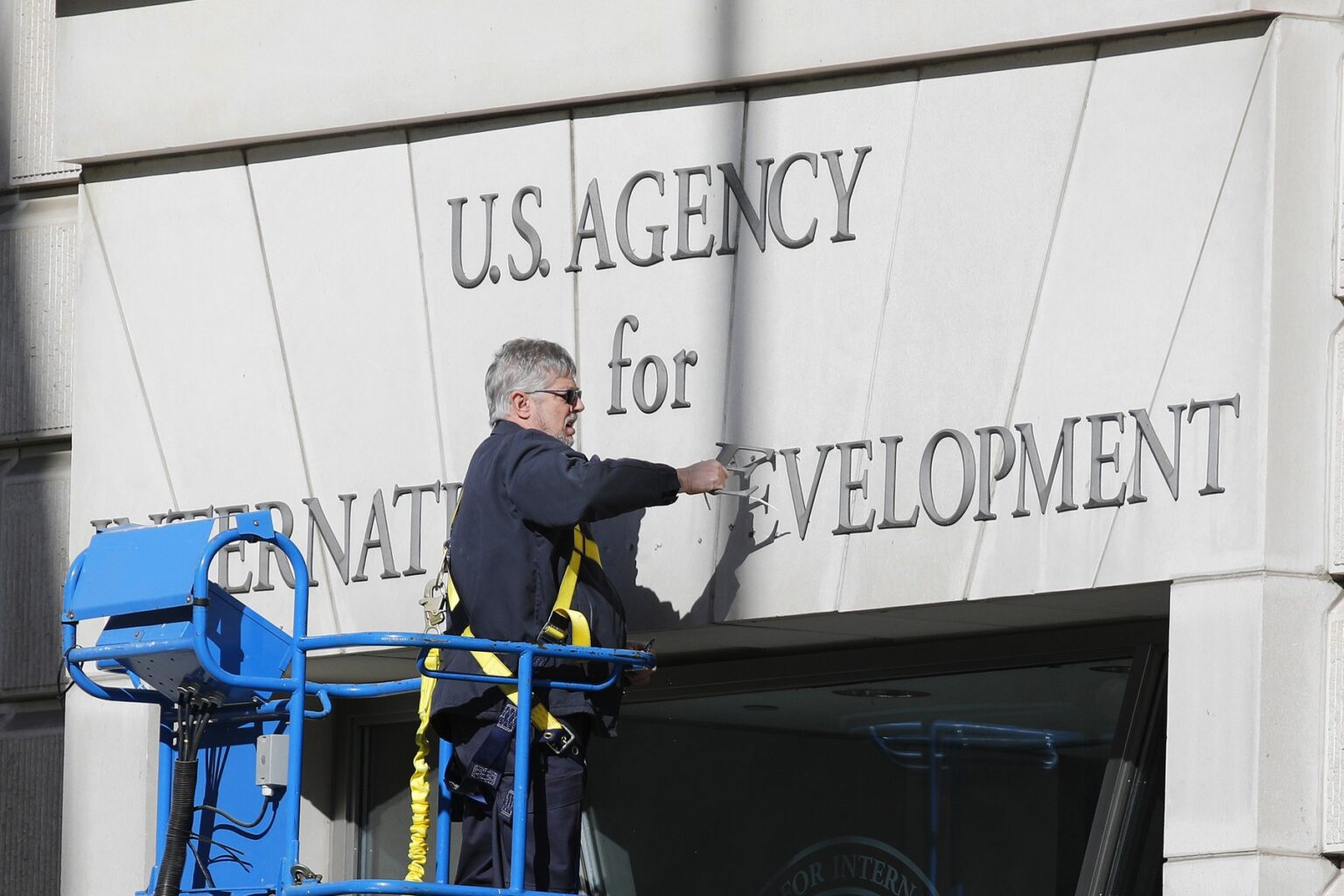 Pracovník odstraňuje označenie vládnej budovy USAID. Foto: Mark Alfred/ZUMA Press Wire / SplashNews.com / Splash / Profimedia