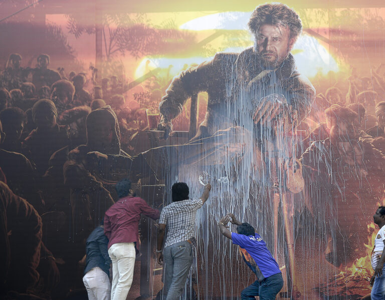 Indian fans spray milk on a billboard displaying the picture of Bollywood star Rajinikanth. Photo: ARUN SANKAR / AFP / AFP / Profimedia