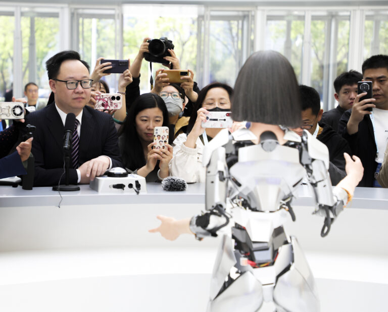 Visitors take photos of an AI generated content (AIGC) humanoid robot on display at the information desk of 2024 Zhongguancun Forum. Photo: Li He/VCG via Getty Images