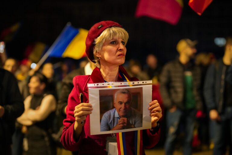 Žena drží portrét Calina Georgesca počas protestu po tom, ako rumunský ústavný súd potvrdil zákaz jeho kandidatúry v opakovaných prezidentských voľbách v Bukurešti v utorok 11. marca 2025. Foto: TASR/AP