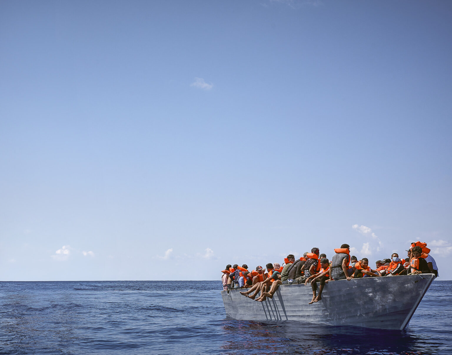 Migrants on a boat in the Mediterranean Sea await rescue.