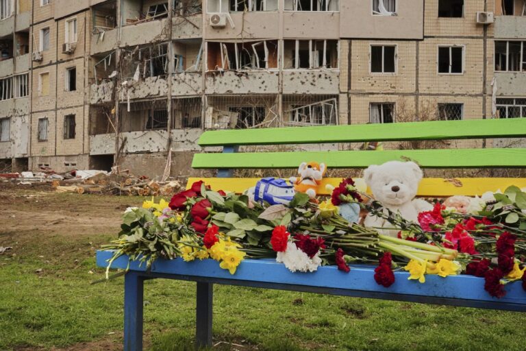 Kvety a hračky na lavičke na pamiatku obetí, ktoré zahynuli pri piatkovom raketovom útoku Ruska, na detskom ihrisku v blízkosti poškodených obytných domov v ukrajinskom meste Krivý Roh v sobotu 5. apríla 2025. Foto: ČTK / AP / Uncredited