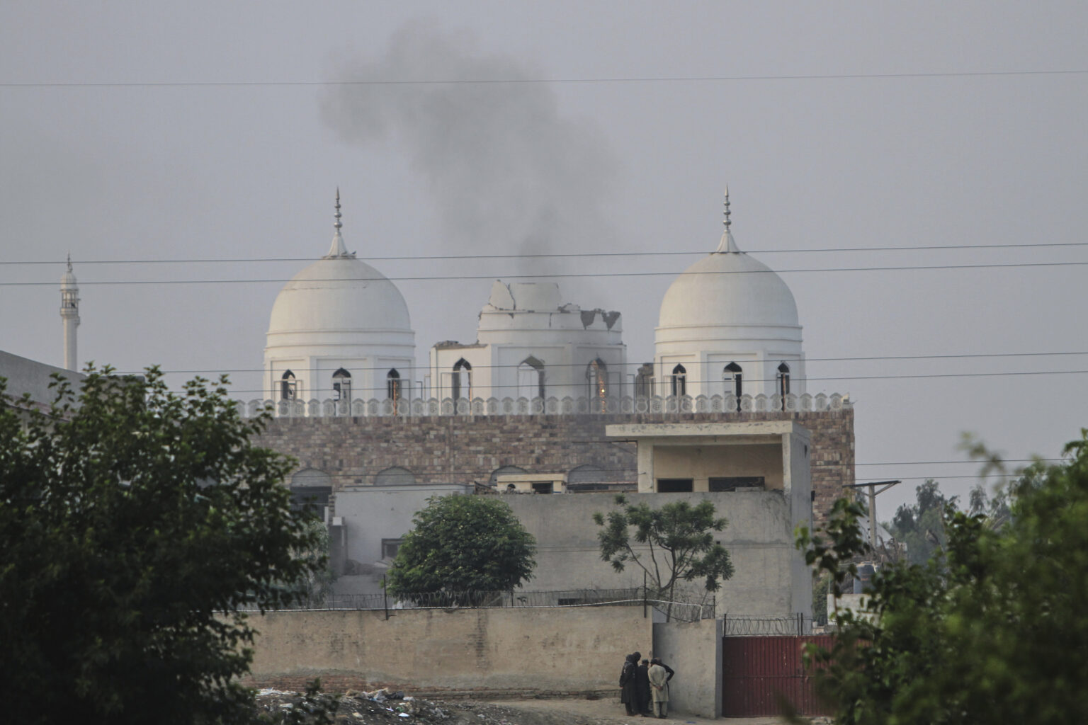 Obyvatelia stoja pred mešitou islamského seminára, ktorá bola čiastočne poškodená indickým raketovým útokom, predmestie pakistanského mesta Bahawalpur, streda 7. mája 2025. Foto: TASR/AP