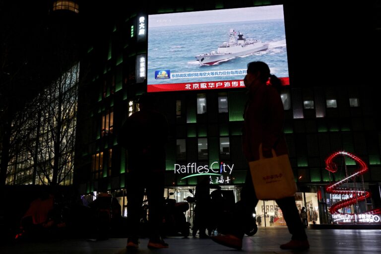 A screen in Beijing shows a Chinese navy vessel.