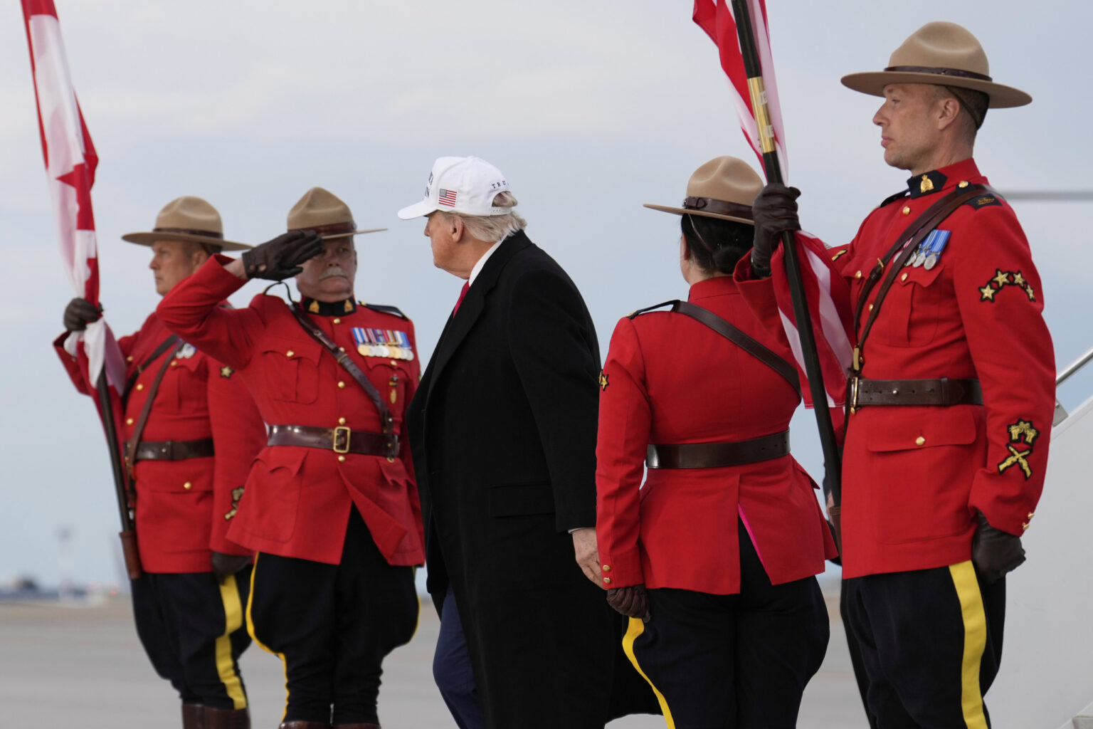 Donald Trump pred samitom G7 obklopený príslušníkmi kanadskej jazdeckej polície na letisku v Calgary. Foto: TASR/AP