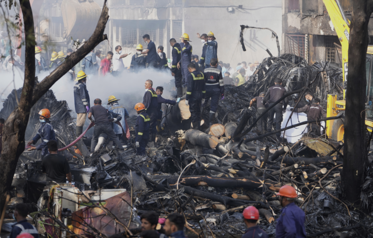 Pátracie a záchranné tímy zasahujú na mieste havárie lietadla v indickom meste Ahmedabad. Foto: TASR/AP