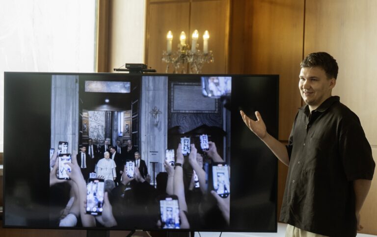 Tomáš Baršváry s fotografiou zo série „Zo dňa na deň stredobodom“ s názvom fotografie Lev XIV. Foto: Martin Baumann/ TASR