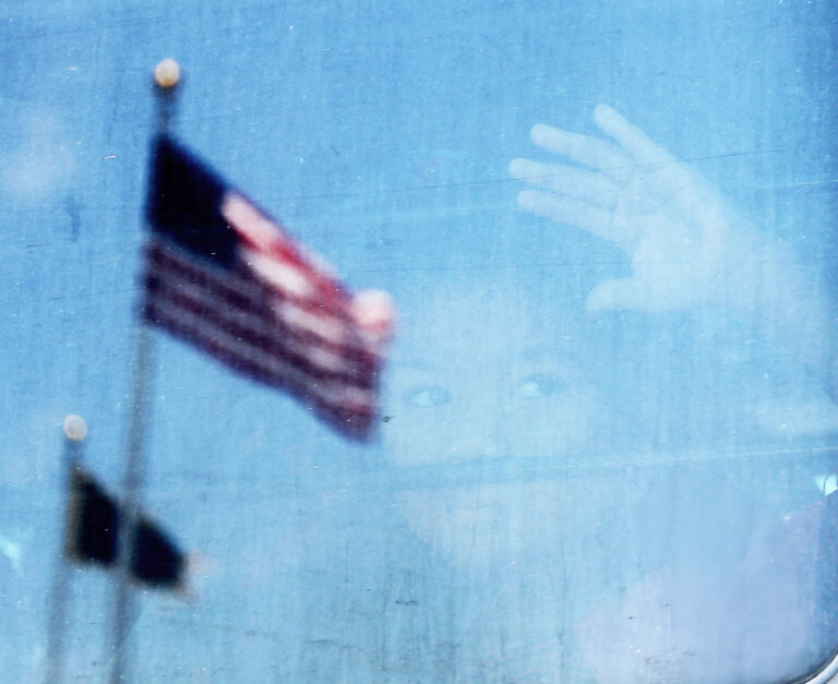 Migrantské dieťa sa pozerá z okna autobusu. Foto: Spencer Platt/Getty Images 
