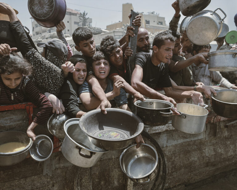 Palestínčania, vrátane detí, čakajú v rade na teplé jedlo, ktoré rozdáva charitatívna organizácia v meste Gaza. Foto: Abdalhkem Abu Riash/Anadolu via Getty Images
