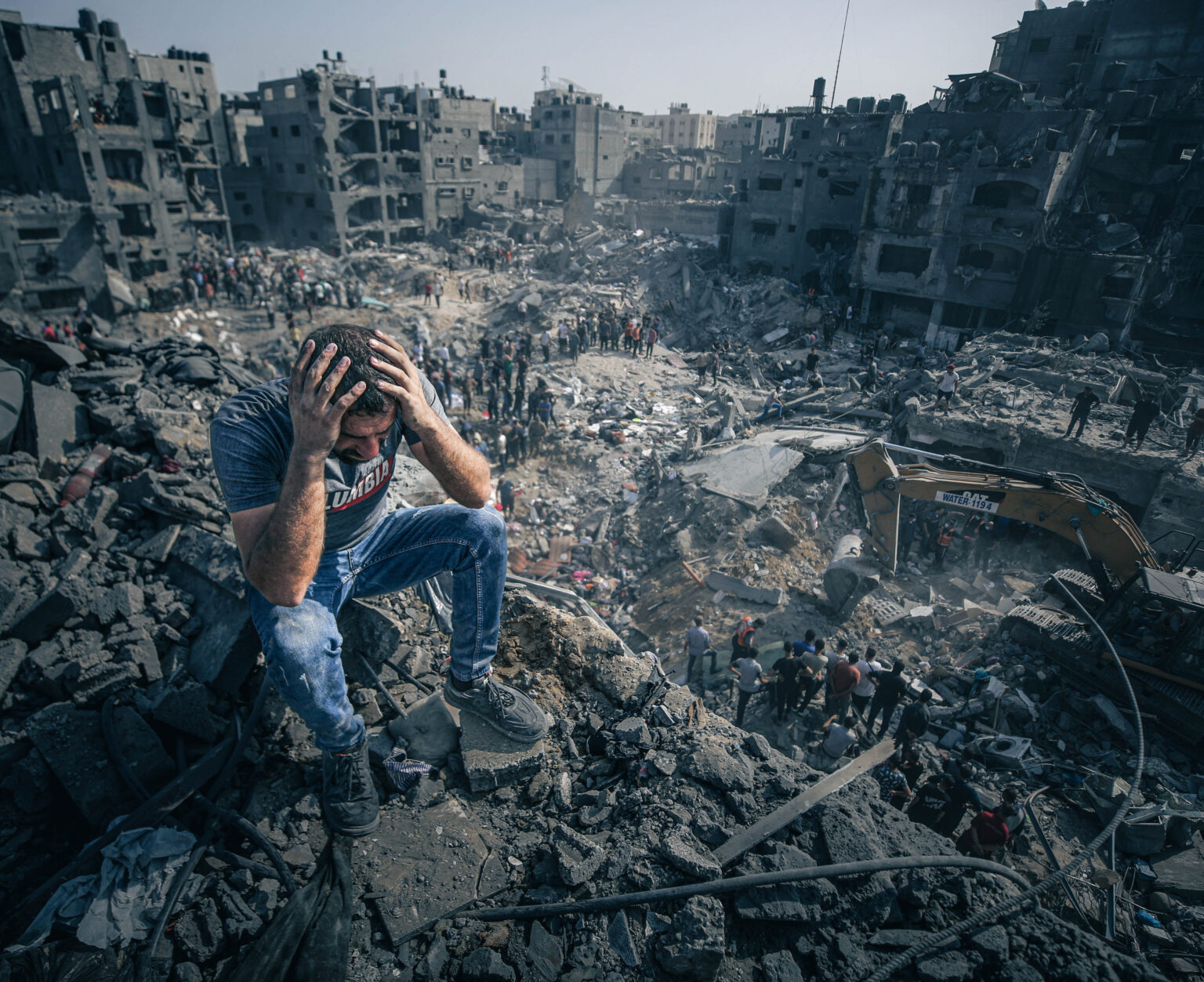 Muž sediaci na troskách reaguje na záchrannú operáciu Palestínčanov po bombardovaní izraelskou armádou. Foto: Ali Jadallah/Anadolu via Getty Images