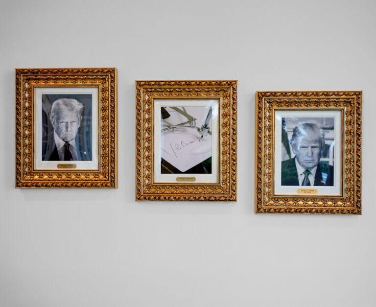 Portrét amerického prezidenta Donalda Trumpa a zarámovaná fotografia automatického pera píšuceho meno bývalého amerického prezidenta Joea Bidena sú súčasťou novej galérie v kolonáde vedúcej do Oválnej pracovne vo Washingtone. Foto: Andrew Harnik/Getty Images