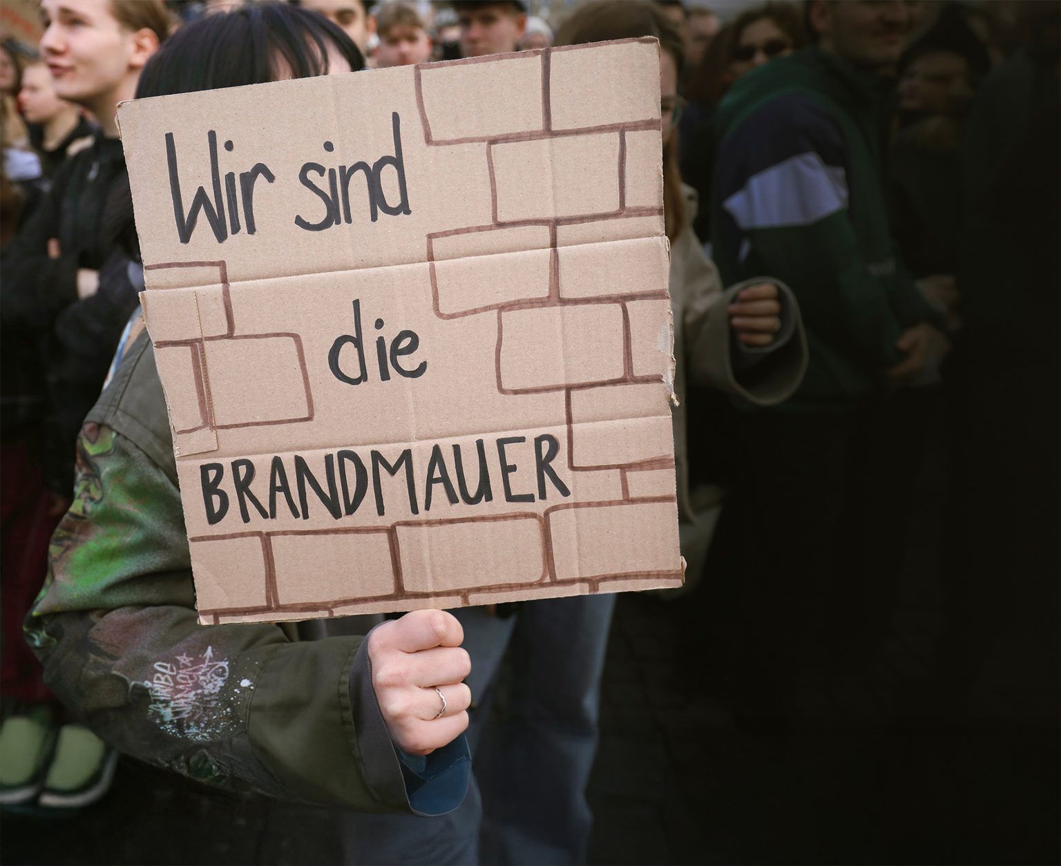 A protester in Thuringia holds a sign reading ‘We are the firewall’ during a demonstration against a shift to the right. Photo: ČTK/imago stock & people/Müller-Stauffenberg/Profimedia