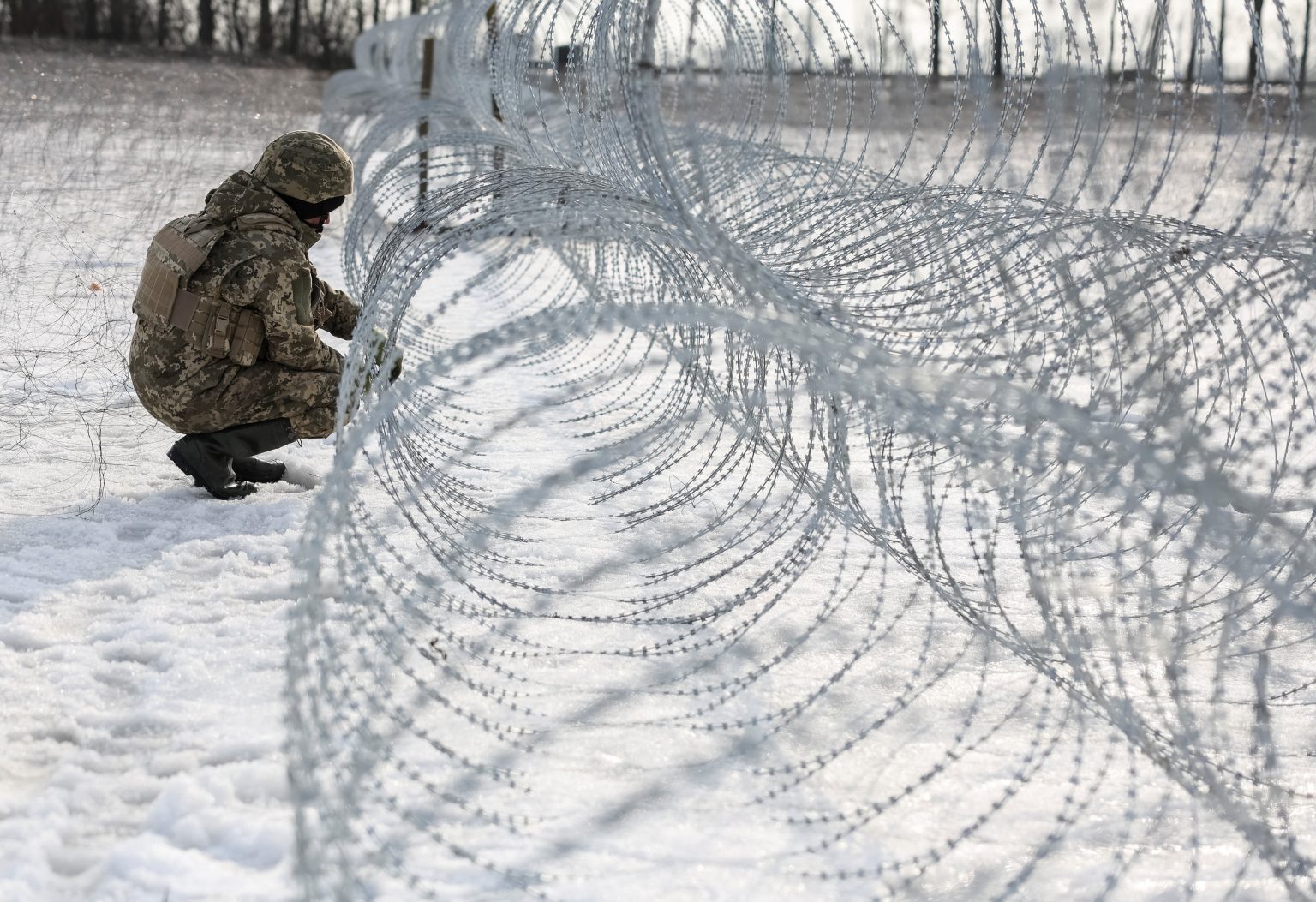 A Ukrainian soldier installs barbed wire near Kupiansk on 2 March 2026. Photo: Radio Liberty/Serhii Nuzhnenko/Reuters