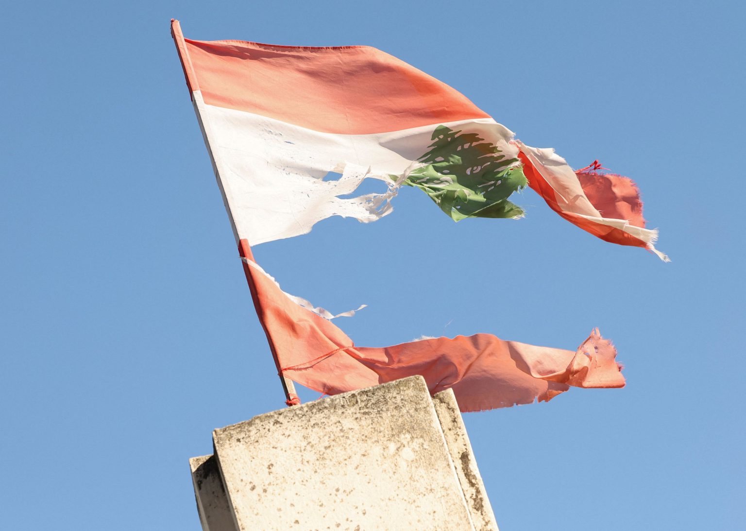 A torn Lebanese flag, symbolising a country caught between Hezbollah’s entrenchment and Israel’s advancing military line. Photo: Amr Abdallah Dalsh/Reuters